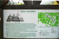 A forest board with a map and a historical note about the village of Caryńskie.